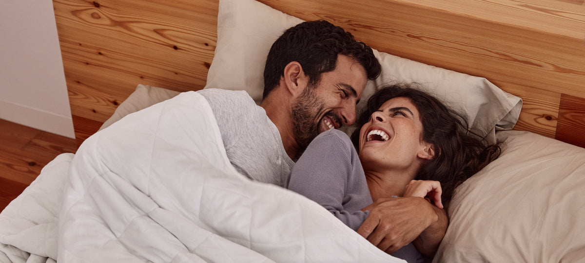 Couple waking up happy under blanky